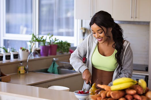 pexels-photo-1153369-1153369 Smiling woman preparing fresh fruit in a sunlit kitchen, embodying a healthy lifestyle.